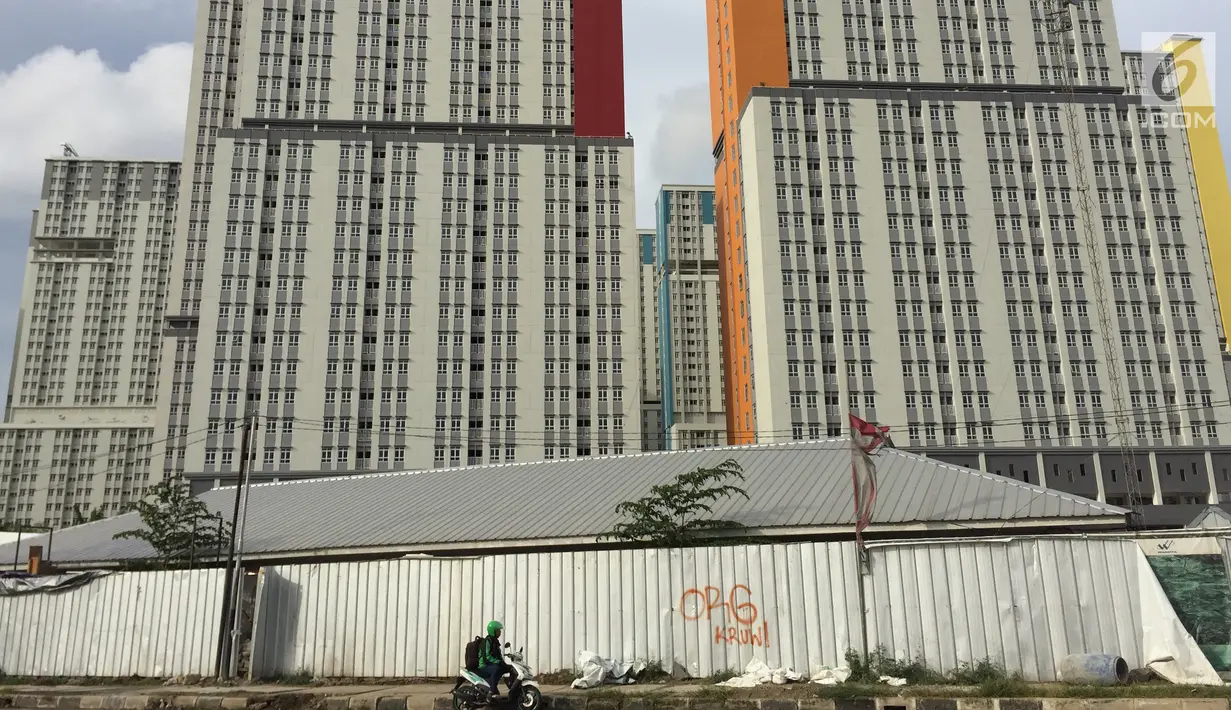 Seorang pengendara ojek online menunggu penumpang di kawasan Kemayoran, Jakarta, Jumat (19/1). Pasokan apartemen existing saat ini mencapai 138.000 unit. (Liputan6.com/Immanuel Antonius)