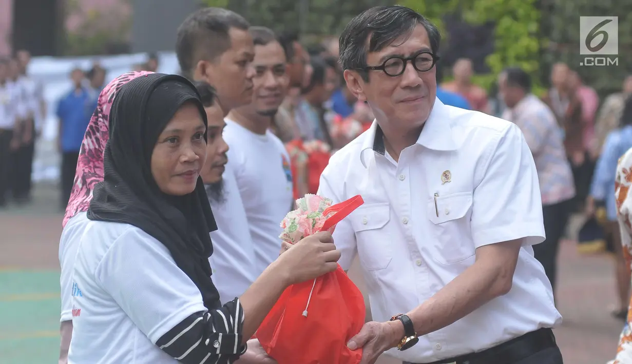 Menkumham Yasona Laoly memberikan bingkisan jelang melepas ratusan pegawai dan keluarganya untuk mudik bersama ke kampung halaman, Jakarta (22/6). Ada 5 bus yang digunakan dalam mudik bersama ini. (Liputan6.com/Helmi Afandi) 