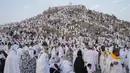 Umat muslim berkumpul di puncak bukit berbatu yang dikenal sebagai Gunung Rahmat di Dataran Arafah saat menunaikan ibadah haji dekat Kota Suci Makkah, Arab Saudi, Sabtu (15/6/2024). (AP Photo/Rafiq Maqbool)