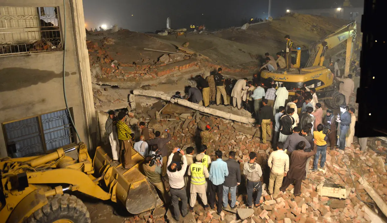 Tim SAR mencari korban di reruntuhan pabrik berlantai lima yang ambruk di Lahore, Pakistan Timur, Rabu (4/11) malam waktu setempat. Sedikitnya 16 orang tewas dan 40 luka-luka akibat kejadian tersebut. (AFP PHOTO/Arif Ali)