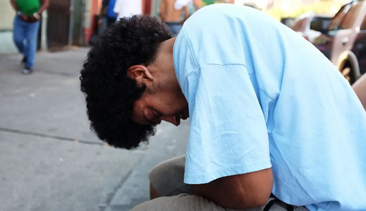 Seorang pria tertidur usai mengisap ganja sintetis atau dikenal dengan K2 di pinggir jalan East Harlem, New York (5/8/2015). Warga AS terutama remajanya tengah kecanduan oleh ganja sintetis atau yang disebut 'Spice'. (AFP PHOTO/SPENCER PLATT)