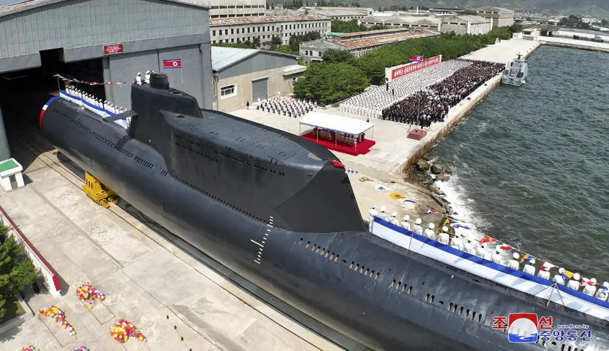 Pemimpin Korea Utara Kim Jong Un memimpin upacara peresmian kapal selam nuklir tersebut dan melakukan inspeksi sehari kemudian. (STR/KCNA VIA KNS/AFP)