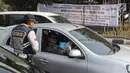 Petugas Dishub DKI membagikan brosur sosialisasi perluasan ganjil genap pada hari pertama uji coba di kawasan Tomang, Jakarta, Senin (2/7). Perluasan diberlakukan di ruas jalan yang terdapat arena pertandingan Asian Games. (Liputan6.com/Arya Manggala)