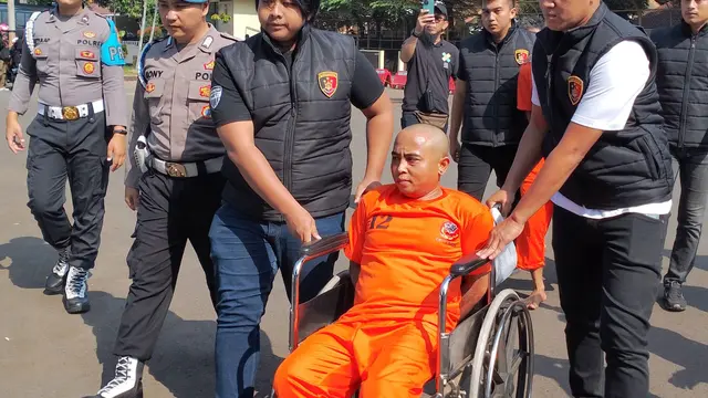 Petugas Satreskrim Polres Garut terpaksa membawa tersangka TR dengan kursi roda setelah sebelumnya berencana menyerang anggota saat usaha penangkatan tersagka di Bekasi. (Liputan6.com/Jayadi Supriadin)