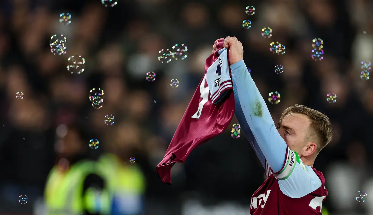Pemain West Ham United, Jarrod Bowen melakukan selebrasi dengan menunjukkan jersey milik Michail Antonio pada laga lanjutan Liga Inggris 2024/2025 melawan Wolves di London Stadium, London, Inggris, Selasa (10/12/2024) WIB. (AFP/Adrian Dennis)