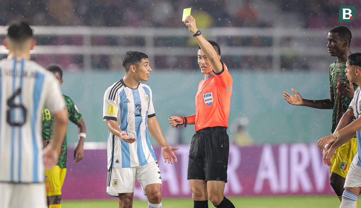 <p>Wasit Fu Ming asal China memberi kartu kuning kepada pemain Timnas Argentina U-17, Octavio Ontivero saat menghadapi Timnas Mali U-17 pada laga perebutan tempat ketiga Piala Dunia U-17 2023 di Stadion Manahan, Solo, Jumat (1/12/2023). (Bola.com/Bagaskara Lazuardi)</p>