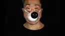 Edmond Kok, aktor dan desainer kostum teater Hong Kong, mengenakan masker dengan model CCTV dipasang di atasnya di Hong Kong pada 6 Agustus 2020. Sepanjang pandemi, Edmond telah membuat lebih dari 170 masker yang terinspirasi oleh pandemi dan masalah politik Hong Kong. (AP Photo/Vincent Yu)