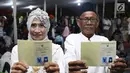Pasangan nikah massal menunjukkan buku nikah usai ijab kabul di jalan MH Thamrin, Jakarta, Senin (31/12). 557 pasangan mengikuti nikah massal dan isbat nikah pada malam pergantian tahun 2018-2019. (Liputan6.com/Helmi Fithriansyah)