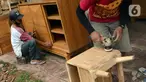 Pekerja menghaluskan furnitur atau perlengkapan rumah berbahan kayu dari Jepara di Ciputat, Tangerang Selatan, Selasa (14/9/2021). Pedagang di tempat tersebut mengakui selama PPKM ini daya beli masyarakat terhadap furnitur meningkat. (Liputan6.com/Johan Tallo)