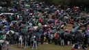 Para penonton memakai payung saat mereka menyaksikan kejuaraan tenis Wimbledon 2017 di The All England Lawn Tennis Club, London (11/7). Walaupun Hujan, Para penonton tetap antusias untuk menyaksikan idolanya bertanding . (AFP Photo/Daniel Leal Olivas)