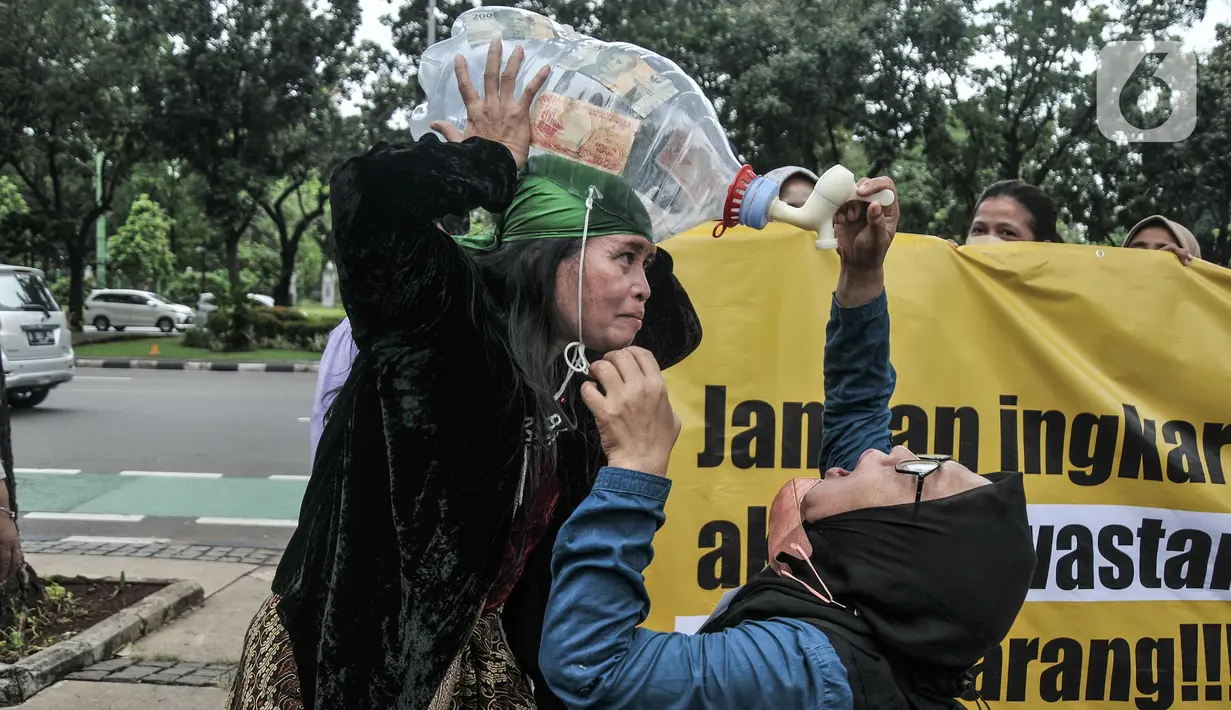 Massa Koalisi Masyarakat Menolak Swastanisasi Air Jakarta (KMMSAJ) melakukan aksi teatrikal di depan Balai Kota, Jakarta Pusat, Selasa (22/3/2022). Mereka menuntut Anies Baswedan membuka partisipasi publik atas proses transisi konsesi pengelolaan air. (merdeka.com/Iqbal S Nugroho)