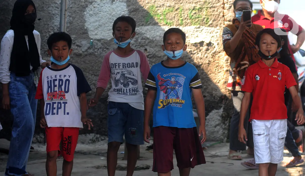 Anak-anak saat mengikuti lomba balap kelereng peringatan HUT Kemerdekaan ke-76 RI di Benda Baru, Pamulang, Tangsel, Selasa (17/8/2021). Di sejumlah kawasan pinggiran Jabotabek warga tetap melaksanakan peringatan HUT kemerdekaaan RI walau masih dalam status PPKM Level 4. (merdeka.com/Arie Basuki)