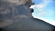 Semburan abu vulkanik Gunung Agung terlihat dari sebuah desa di Kecamatan Kubu, Karangasem, Bali, Minggu (26/11). Semburan asap dan abu vulkanik Gunung Agung mencapai ketinggian 1.500 meter dari puncak Gunung Agung. (AFP/Sonny Tumbelaka)