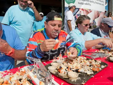 Para peserta beradu cepat memakan daging kepiting batu dalam kontes Key Fisheries Stone Crab Eating di Marathon, Florida, Sabtu (10/11). Mereka harus memecahkan cangkang 25 kepiting batu lalu memakan dagingnya. (Andy Newman/Florida Keys News Bureau/AFP)