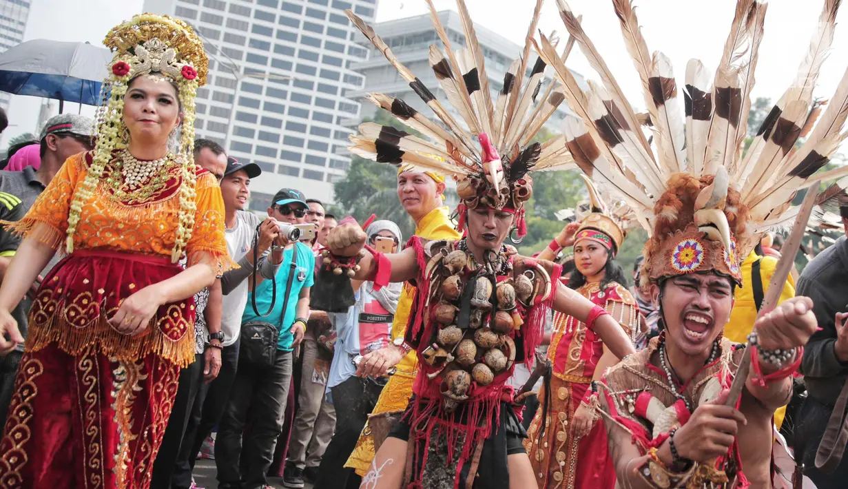 Atraksi budaya dayak meramaikan Car Free Day (CFD) di kawasan Sudirman, Jakarta, Minggu (29/10). Kegiatan tersebut juga sekaligus mengajak masyarakat Indonesia untuk berwisata ke kabupaten Tabalong, Kalimantan Selatan. (Liputan6.com/Faizal Fanani)