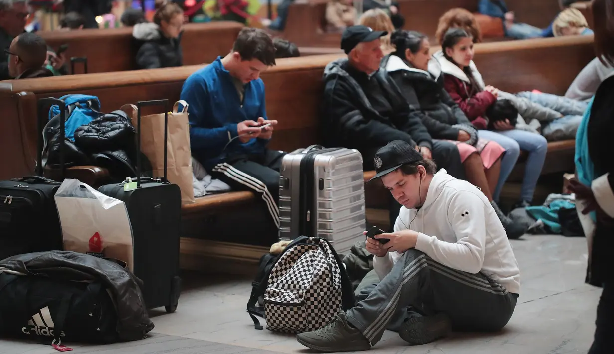 Wisatawan menunggu jadwal kedatangan kereta di Union Station, Chicago, Rabu (21/11). Masyarakat Amerika mulai bergegas pulang ke kampung halamannya alias mudik untuk merayakan Thanksgiving Day. (SCOTT OLSON/ Getty Images/AFP)
