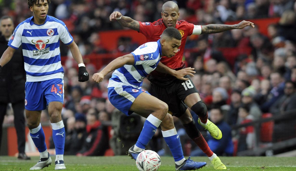 Bek Manchester United, Ashley Young, berebut  bola dengan pemain Reading, Andy Rinomhota, pada laga Piala FA di Stadion Old Trafford, Sabtu (5/1). Manchester United menang 2-0 atas Reading. (AP/Rui Vieira)