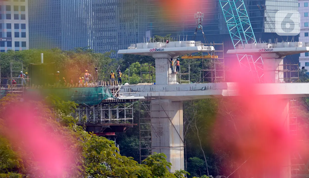 Para pekerja sedang menyelesaikan bentangan beton panjang light rail transit (LRT) di tikungan Jembatan 66 Kuningan-Dukuh Atas, Jakarta, Senin (6/7/2020). (merdeka.com/Dwi Narwoko)