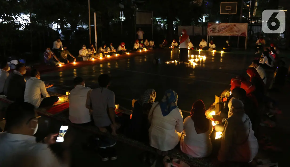 Sejumlah relawan menyalakan lampu pada malam renungan Hari AIDS Sedunia di Tanah Abang, Jakarta, Rabu (1/12/2021). Acara ini mengampanyekan kepada masyarakat untuk mewaspadai penularan virus HIV/AIDS dan lebih berempati pada penderitanya. (Liputan6.com/Herman Zakharia)