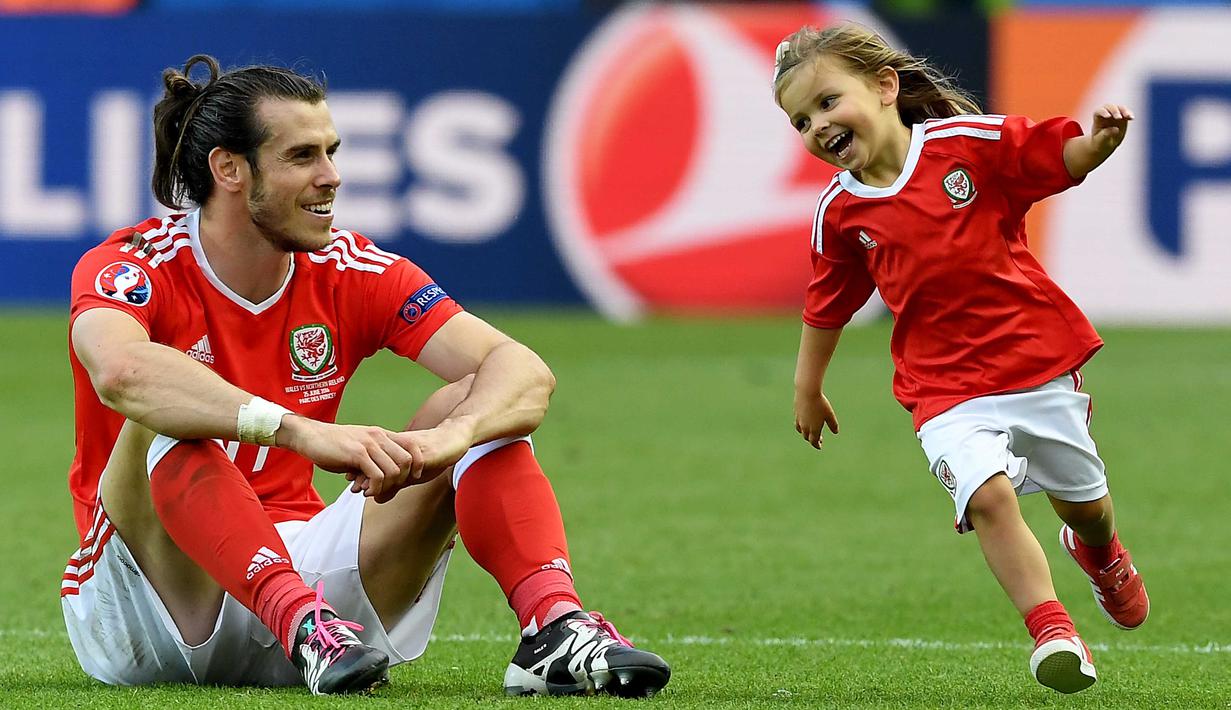 Gareth Bale duduk menyaksikan keceriaan putrinya, Alba Violet usai laga melawan Irlandia Utara pada Piala Eropa 2016 di Parc des Princes, Paris, (25/6/2016). Wales Menang 1-0. (EPA/Georgi Licovski)