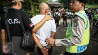 Seorang warga diciduk petugas Satuan narkoba Polres Jakut pada penggerebekan di Kampung Bahari, Tanjung Priok, Jakarta, Kamis (25/8). Penggerebekan melibatkan ratusan personel gabungan. (Liputan6.com/Faizal Fanani)