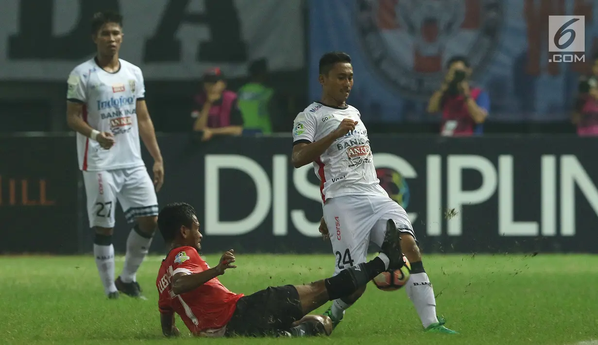 Gelandag Persija, Ramdani Lestaluhu (tengah) berebut bola dengan pemain Bali United, Ricky Fajrin Saputra dilanjutan Liga 1 Indonesia di Stadion Patriot Candrabhaga, Minggu (21/5). Laga kedua tim berakhir imbang 0-0. (Liputan6.com/Helmi Fithriansyah)