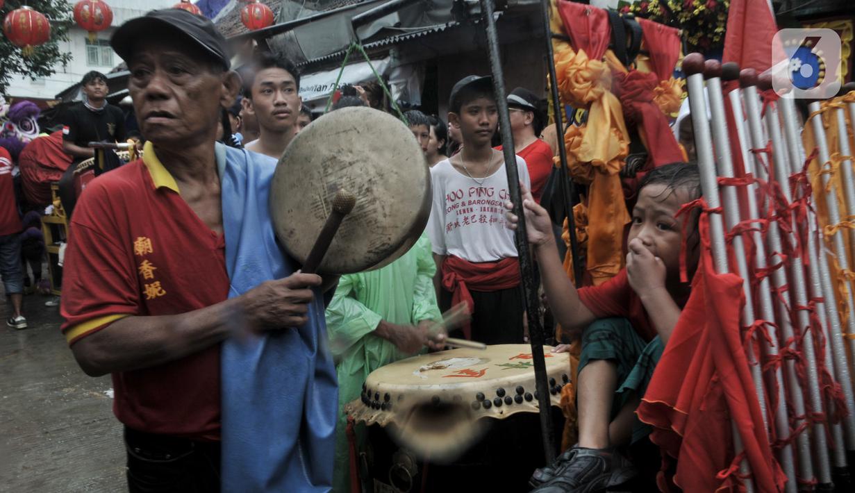 Iringan musik tradisional Tionghoa saat perayaan Cap Go Meh Tahun Baru Imlek 2571 di Jatinegara, Jakarta, Minggu (9/2/2020). Meski hujan, perayaan Cap Go Meh berlangsung meriah dengan atraksi barongsai dan liong serta arakan dewa-dewa mengelilingi kawasan Jatinegara. (merdeka.com/Iqbal S Nugroho)