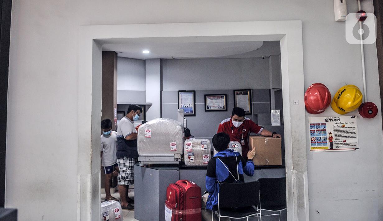 Petugas mengemas barang costumer yang akan dikirim melalui jasa ekspedisi JNE di Tomang, Jakarta, Selasa (29/12/2020). Peningkatan jasa ekspedisi terjadi seiring kian maraknya warga yang membeli barang melalui e-commerce. (merdeka.com/Iqbal S. Nugroho)