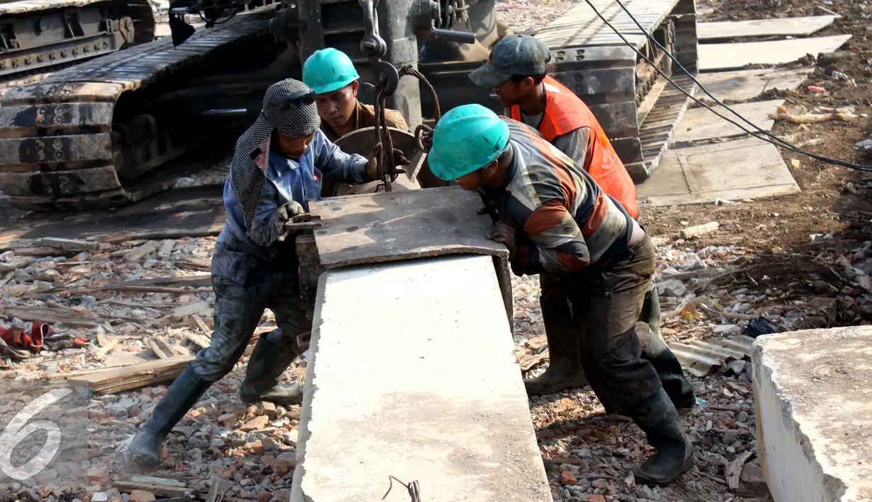 Sejumlah pekerja menyiapkan tiang pancang untuk pemasangan turap di Kali Ciliwung, Kampung Pulo, Jakarta (26/08/15). Pemprov DKI Jakarta menargetkan pemasangan turap selesai dalam waktu tiga bulan. (Liputan6.com/Gempur M Surya)