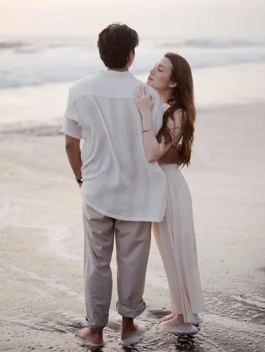 Di momen bahagianya tersebut, keduanya tampak kompak mengenakan pakaian serba putih. Sangat cocok dengan pemandangan deburan ombak dan pasir putih. [@donnywg@lovoto.bali @adisukamotret]
