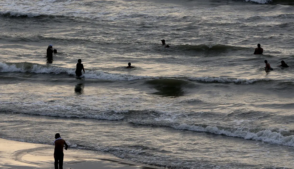 Warga Iran berenang saat sore hari di pantai di kota Laut Kaspia, Izadshahr, di provinsi Mazandaran utara (8/7/2019). Nama “Kaspia” awalnya digunakan untuk menyebut suku pedalaman yang tinggal di wilayah sebelah barat Laut Kaspia yang bernama Transkaukasia. (AFP Photo/Atta Kenare)