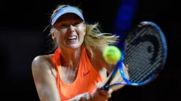 Petenis asal Rusia, Maria Sharapova berusaha memukul bola saat melawan petenis Italia, Roberta Vinci dalam pertandingan putaran pertama Grand Prix WTA di Stuttgart, Jerman (26/4). (AFP Photo/Thomas Kienzle)