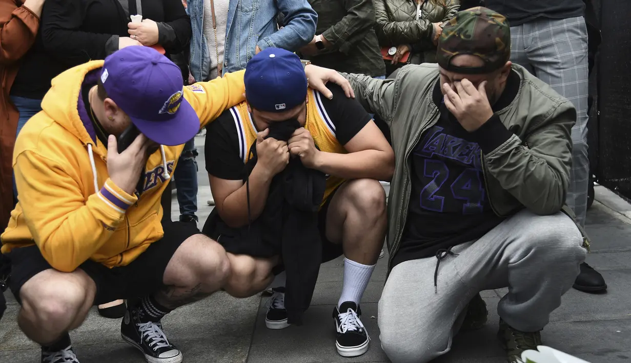 Fans Los Angeles Laker berduka meninggalnnya pebasket NBA Kobe Bryant di luar Staples Center di luar Staples Center, Los Angeles (26/1/2020). Kobe Bryant meninggal di usia 41 tahun akibat kecelakaan helikopter di Calabasas, California, Minggu 26 Januari waktu setempat. (AP Photo/Chris Pizzello)