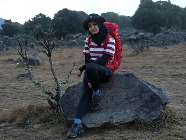 Penampilan Arafah cukup santai saat mendaki Gunung Gede. Berpose di sebuah batu besar, runner up SUCA 2 ini menggunakan baju kaus belang berwarna merah putih dan celana hitam, gayanya saat naik gunung sangat meyakinkan.  (Liputan6.com/IG/@arafahrianti)