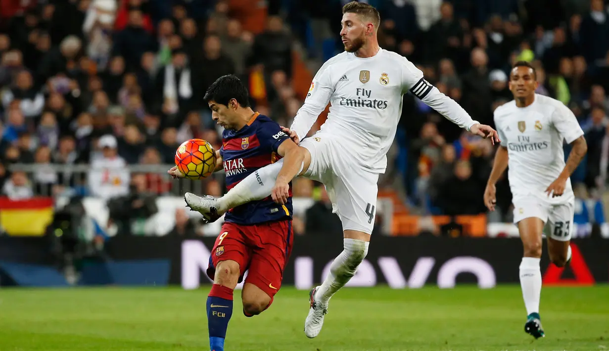 Penyerang Barcelona Luis Suarez (kiri) saat berebut bola dengan bek Real madrid Sergio Ramos di stadion Santiago Bernabeu, Spanyol, (22/11). Gol Barcelona dicetak oleh Luis Suarez dengan dua gol dan sisanya oleh Iniesta dan Neymar. (Reuters/Paul Hanna)