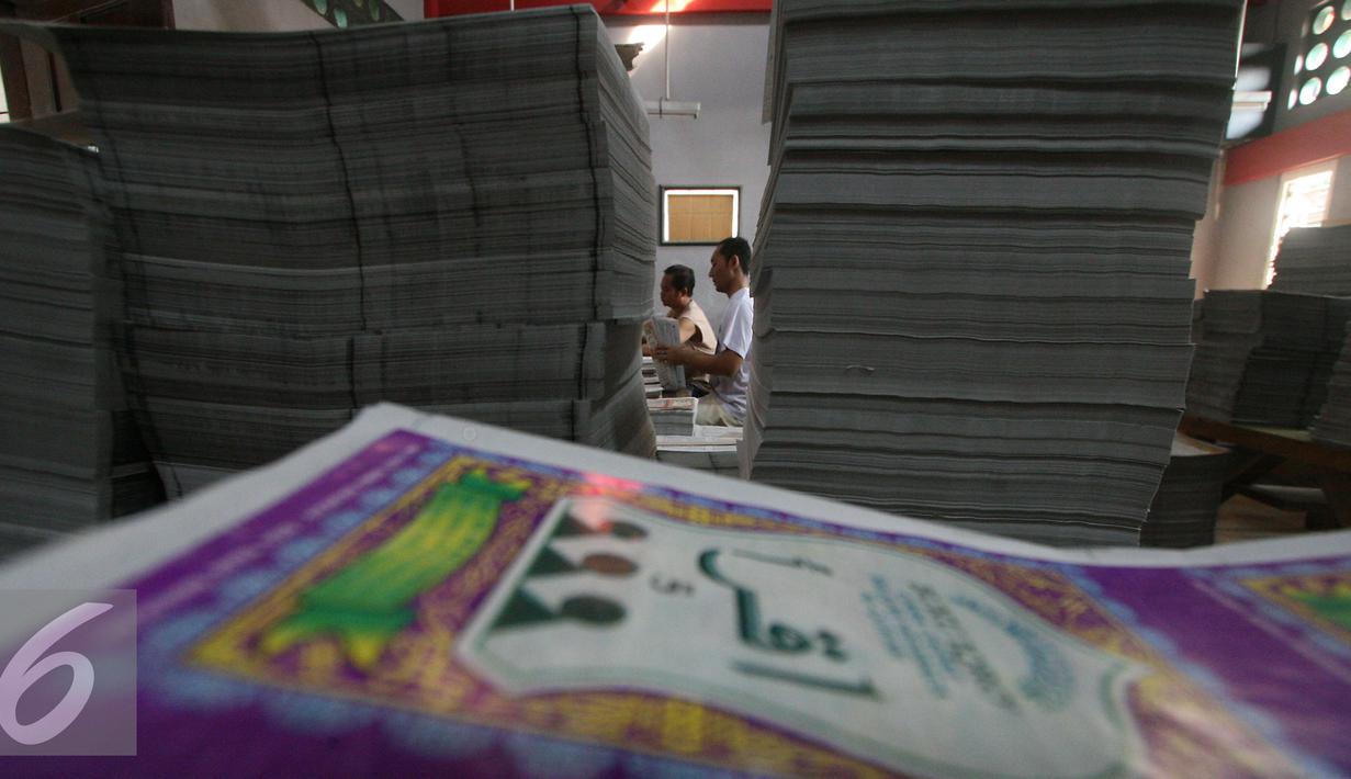 Pekerja menyusun lembaran  buku iqro di Kota Gede, Yogyakarta, (13/6). Selama bulan ramadan produksi tetap berjalan untuk memenuhi permintaan masyarakat yang ingin belajar membaca alquran dengan cepat. (Liputan6.com/Boy Harjanto)