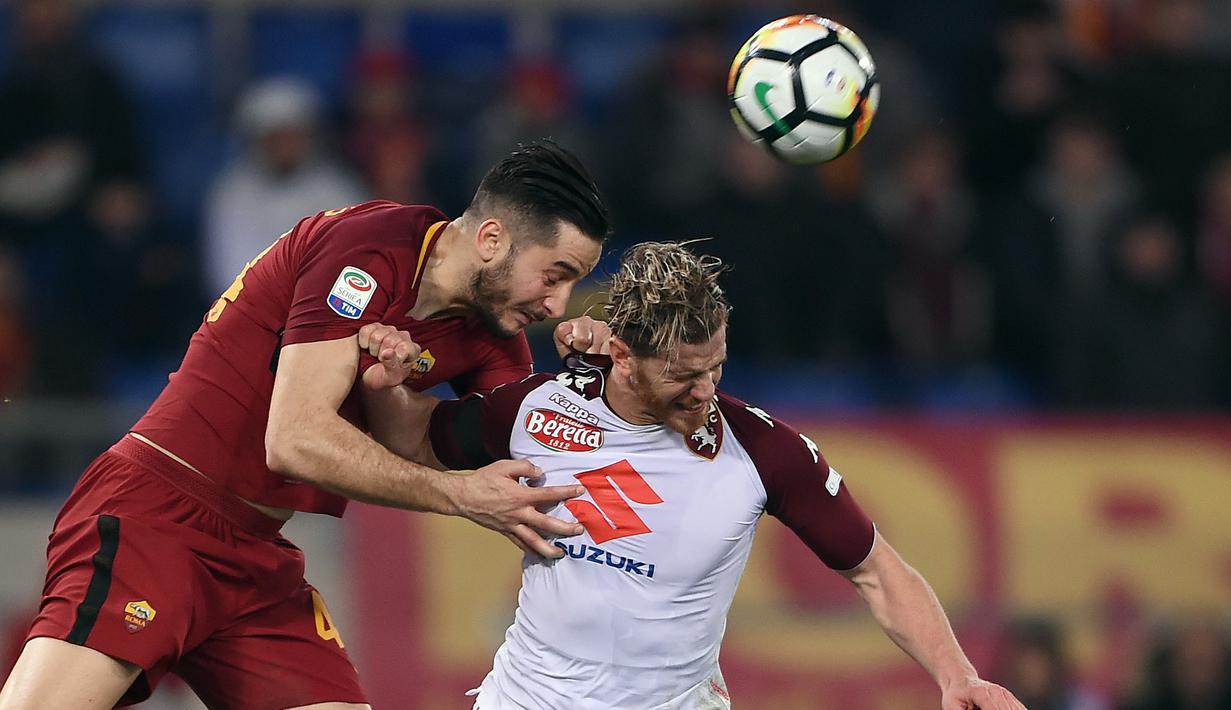 Pemain AS Roma, Kostas Manolas (kiri) berusaha menyundul bola dari pemain Torino, Cristian Ansaldi pada laga Serie A di Olympic Stadium, Roma, (9/3/2018). Roma menang 3-0. (AFP/Filippo Monteforte)