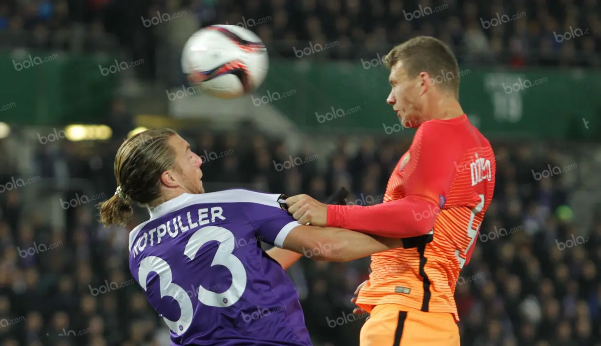 Sundulan bomber AS Roma, Edin Dzeko (kanan) tidak mampu dihalau bek FK Austria Wien, Lukas Rotpuller. (Bola.com/Reza Khomaini)