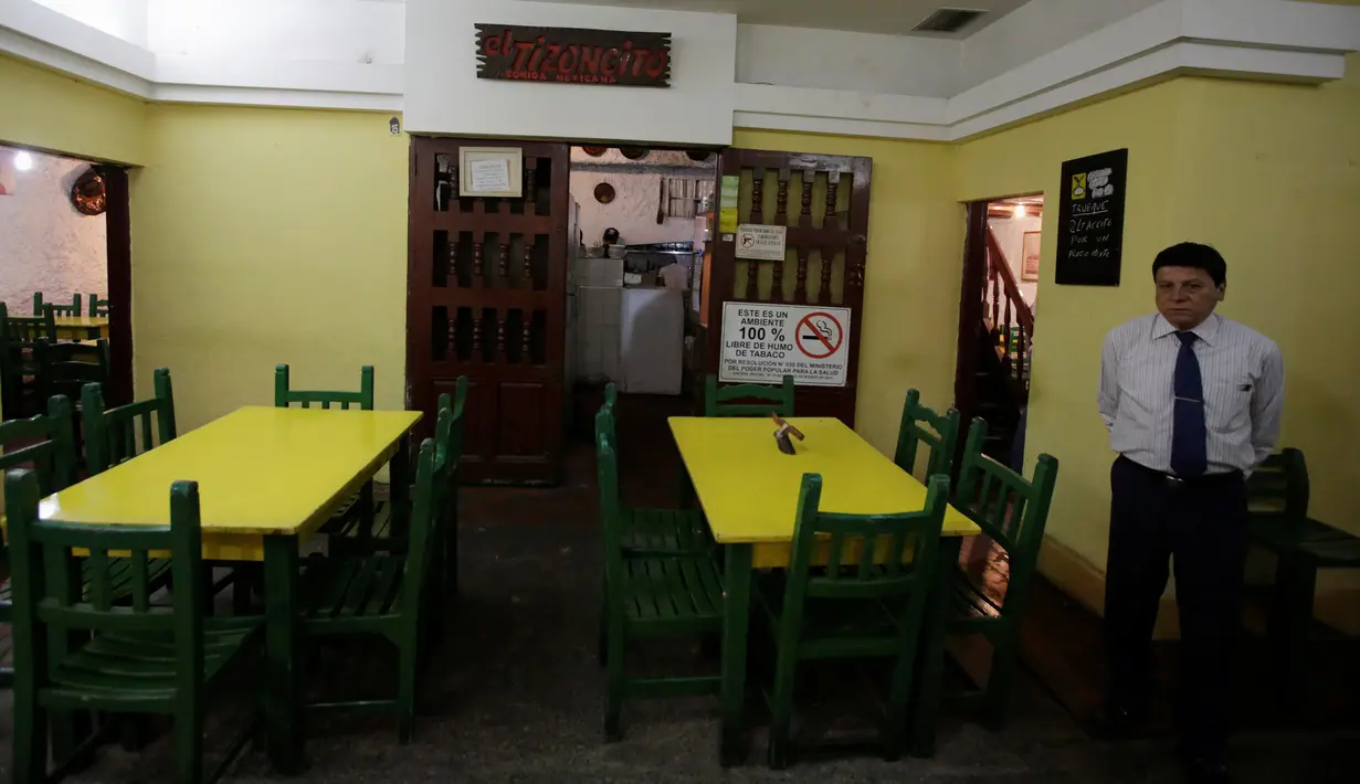 Seorang pekerja saat menunggu pelanggan di restoran El Tizoncito, Caracas, 13 September 2016. Karena krisis ekonomi di Venezuela, restoran ini menawarkan seporsi makanan yang bisa ditukar dengan 2 liter minyak goreng. (REUTERS/Henry Romero)