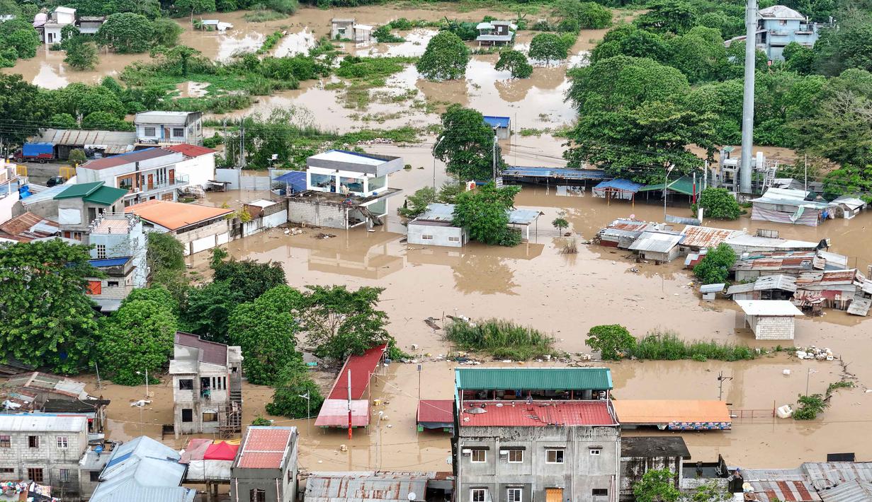 Upaya bantuan bagi pengungsi terus dilakukan, termasuk distribusi makanan dan pemeriksaan kesehatan di pusat-pusat evakuasi. Tampak foto udara menunjukkan pemandangan rumah-rumah yang terendam banjir di Kota Tuguegarao, Provinsi Cagayan, di utara Manila pada 10 November 2025, setelah sungai meluap akibat hujan deras yang disebabkan oleh Topan Super Fung-wong. (John DIMAIN/AFP)