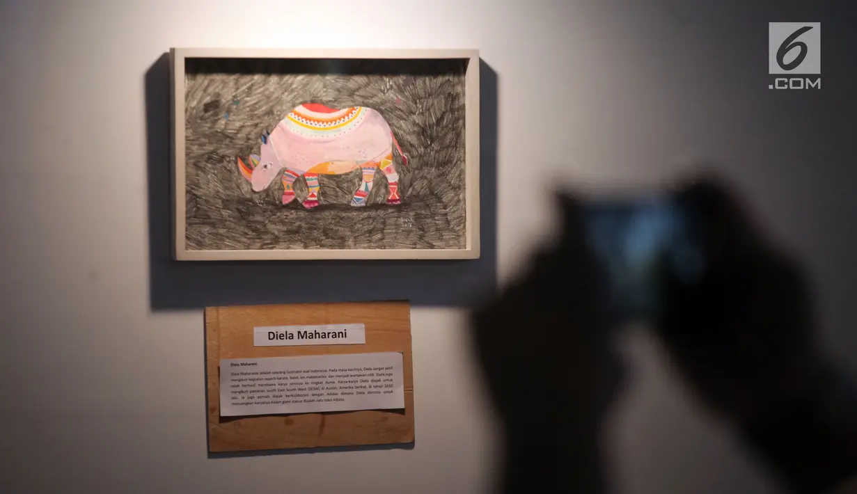 Seorang pengunjung mengambil gambar dalam pameran seni badak Sumatera di Perpustakaan Nasional Indonesia, Jakarta Pusat, Jumat (19/1). Pameran ini sebagai bentuk upaya pelestarian badak Sumatera yang hampir punah. (Liputan6.com/Arya Manggala)