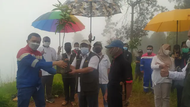 Area Manager PGE Karaha Andi Joko Nugroho menyerahkan bibit pohon ganitri kepada Kepala Dinas Kehutanan Provinsi Jawa Barat Epi Kustiawan, saat pelaksanaan penghijauan di area lahan kritis Kawah Karaha, Tasikmalaya.