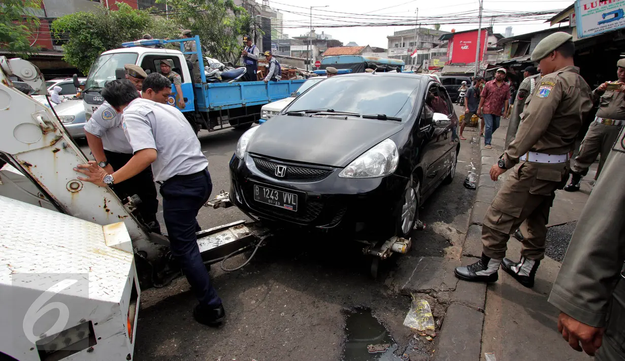 Sebuah mobil yang parkir liar diangkut Sudinhub di Pasar Tanah Abang, Jakarta, Kamis (4/5). Penertiban dilakukan agar mengurai kemacetan. (Liputan6.com/Johan Tallo)