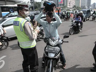 Petugas memberhentikan pengendara roda dua saat operasi patuh jaya dikawasan Thamrin, Jakarta, Selasa (24/5/2016). Selama Operasi Patuh Jaya 2016, Ditlantas Polda Metro Jaya mencatat terjadi 38.622 pelanggar lalu lintas. (Liputan6.com/Faizal Fanani)