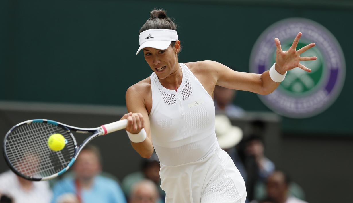 Garbine Muguruza berusaha mengembalikan bola ke arah lawannya Magdalena Rybarikova pada laga semifinal tunggal putri Wimbledon 2017 di London, (13/7/2017). (AP/Kirsty Wigglesworth)