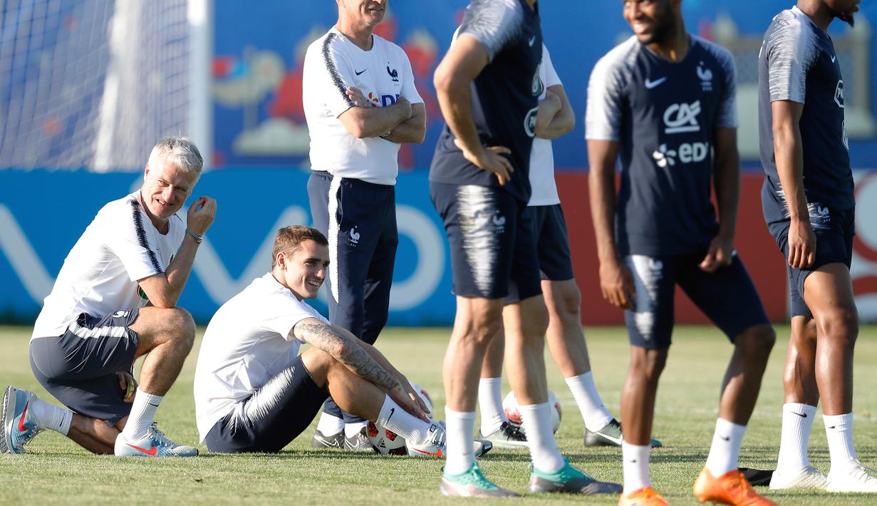 Pelatih Timnas Prancis, Didier Deschamps (kiri) dan gelandang Antoine Griezmann tersenyum saat latihan di Glebovets, Rusia, (12/7). Prancis akan bertanding melawan Kroasia pada babak Final Piala Dunia 2018. (AP Photo / David Vincent)