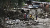 Anggota tim penyelamat mencari di antara puing-puing rumah yang hancur untuk mencari korban atau penyintas setelah tanah longsor saat hujan lebat di Las Tejerias, negara bagian Aragua, Venezuela, pada 10 Oktober 2022. Tanah longsor di Venezuela tengah menewaskan sedikitnya 22 orang dan banyak lagi. dari 50 hilang setelah hujan lebat menyebabkan sungai meluap, Wakil Presiden Delcy Rodriguez mengatakan. (AFP/Yuri Cortez)