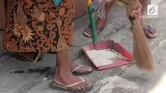 Seorang nenek puluhan tahun menjadi pemungut beras di Pasar Legi Solo.