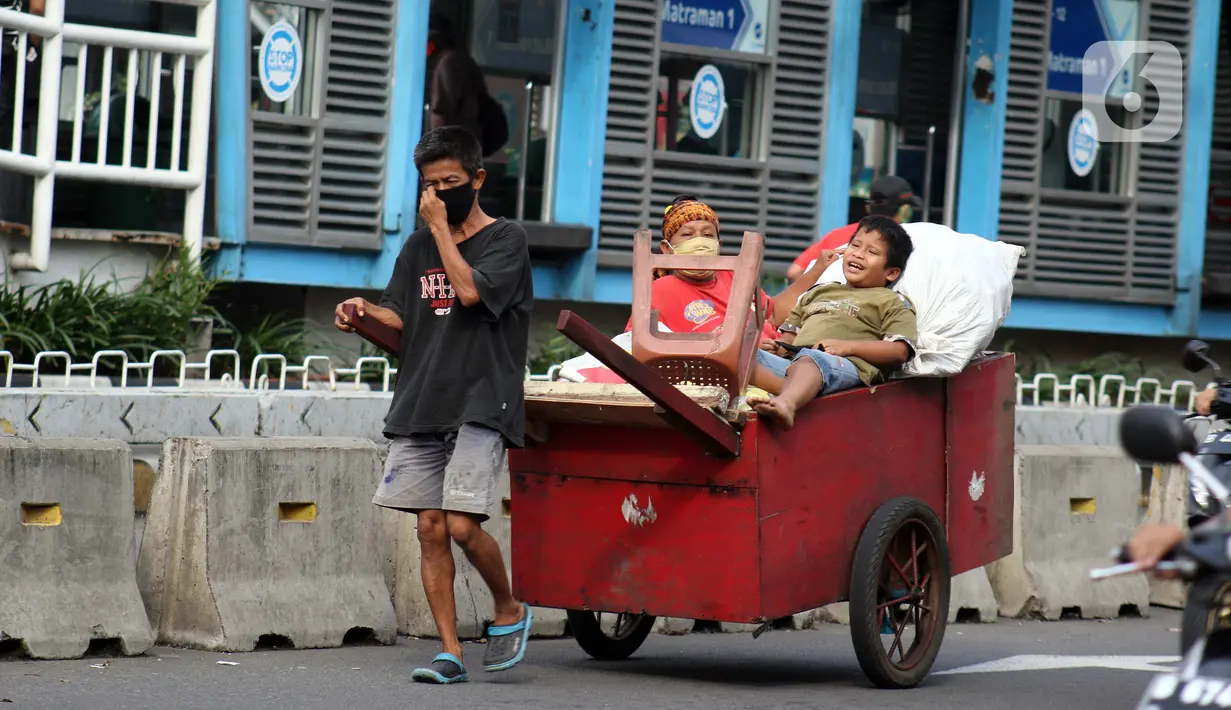 Pemulung melintas di Jalan Matraman Raya, Jakarta, Kamis (30/4/2020). Setiap Ramadan tiba, kemunculan pemulung yang membawa gerobak marak terjadi. Saat ini, kemunculan mereka menjadi masalah tersendiri di tengah upaya memutus mata rantai penyebaran Covid-19. (Liputan6.com/Helmi Fithriansyah)