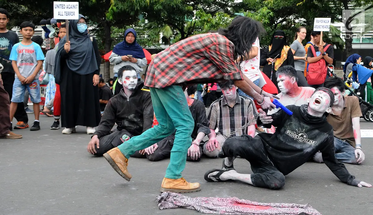 Massa aksi yang tergabung dalam Gerakan Solidaritas Umat Muslim menggelar teatrikal penembakan di Masjid Selandia Baru pada CFD di Bundaran HI, Jakarta, Minggu (17/3). Mereka mengutuk penembakan terhadap jemaah. (Liputan6.com/Herman Zakharia)